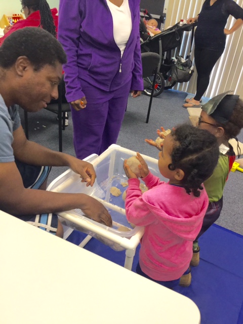 A father playing with his child at make-it take-it.